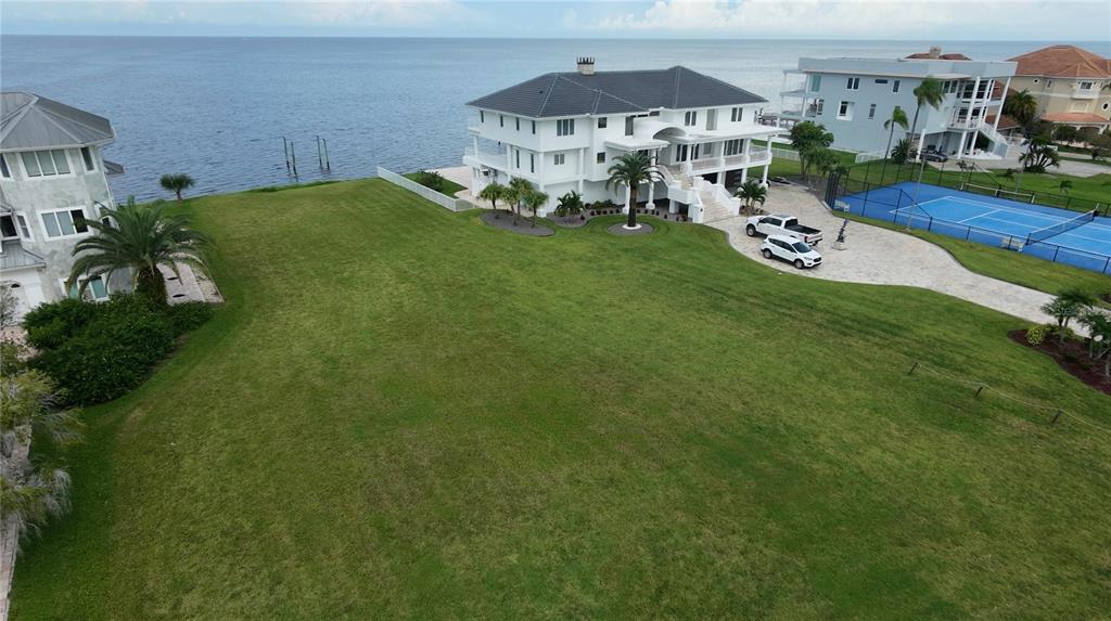 A vibrant orange sunset glows over a calm body of water at the horizon — 5141 WESTSHORE DRIVE, NEW PORT RICHEY, FL