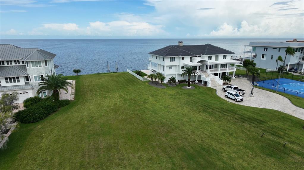 The sun sets over a calm ocean with a sandy beach in the foreground — 5141 WESTSHORE DRIVE, NEW PORT RICHEY, FL