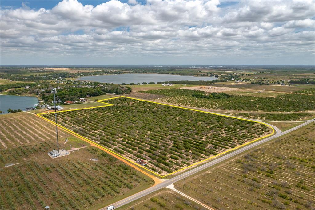 An aerial view shows a large, rectangular agricultural plot outlined in yellow near a lake — SCENIC HIGHWAY N, BABSON PARK, FL