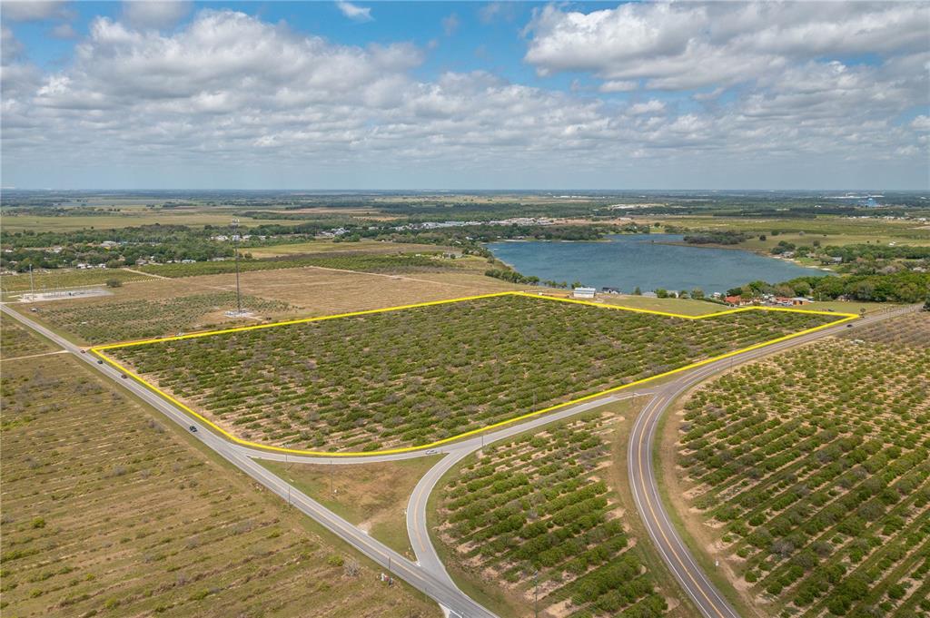 An aerial view shows a large, rectangular plot of land outlined in yellow near roads — SCENIC HIGHWAY N, BABSON PARK, FL