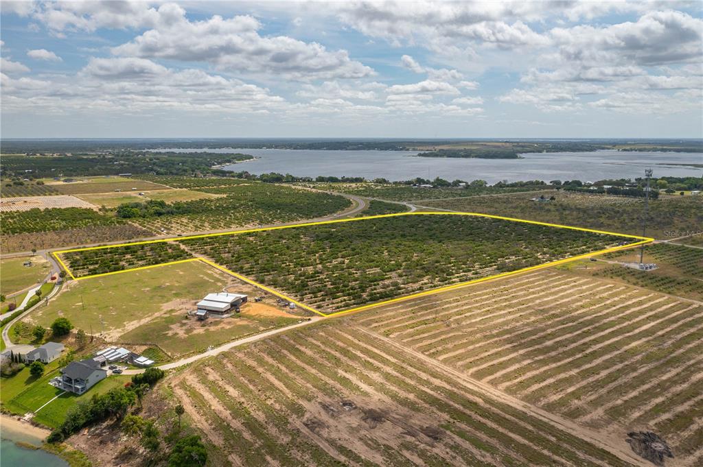 An aerial view shows a large, yellow-outlined agricultural plot of land near a lake — SCENIC HIGHWAY N, BABSON PARK, FL