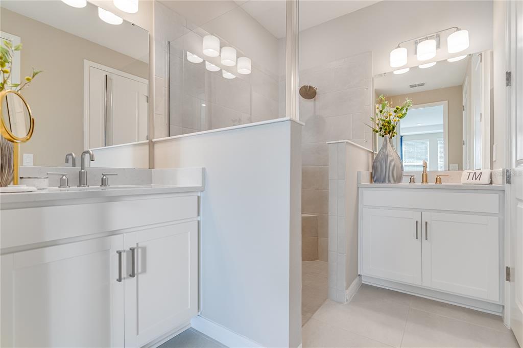 A modern kitchen features white cabinetry, stainless steel appliances, and a marble-patterned backsplash — 1224 TEAL CREEK DRIVE, ST CLOUD, FL
