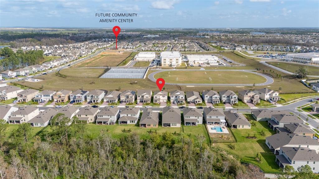 An aerial view shows a suburban neighborhood with houses, a school, and a vacant lot — 18339 OLIVER TWIST WAY, WINTER GARDEN, FL