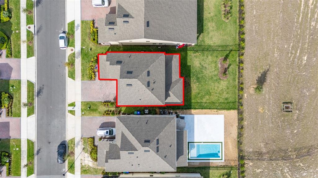 This aerial view shows a residential neighborhood with houses, driveways, and a backyard swimming pool — 18339 OLIVER TWIST WAY, WINTER GARDEN, FL