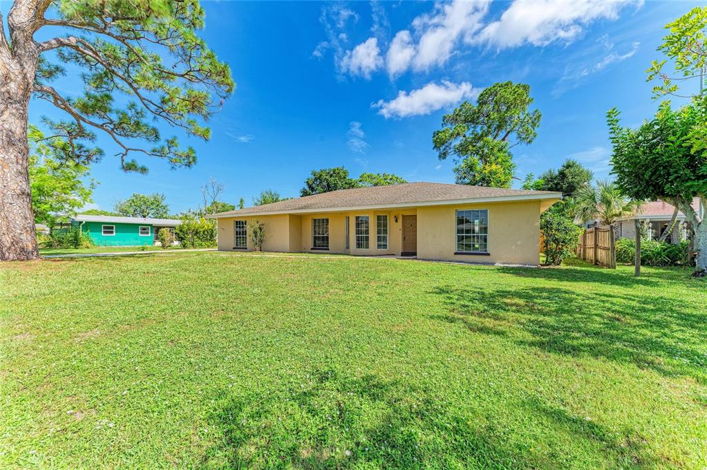 A single-story, tan-colored house with a hip roof sits on a large, grassy lawn — 4404 18TH AVENUE W, BRADENTON, FL