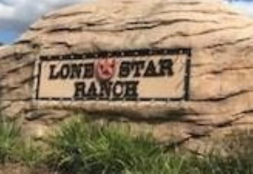 A large, textured stone monument displays the words Lone Star Ranch in a black frame — 15746 STABLE RUN DRIVE, SPRING HILL, FL