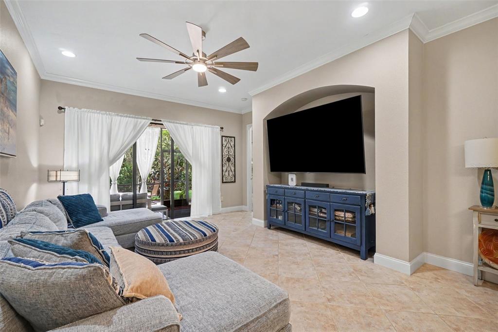 A living room features a sectional sofa, a blue media console, and a ceiling fan — 6103 25TH STREET E, ELLENTON, FL
