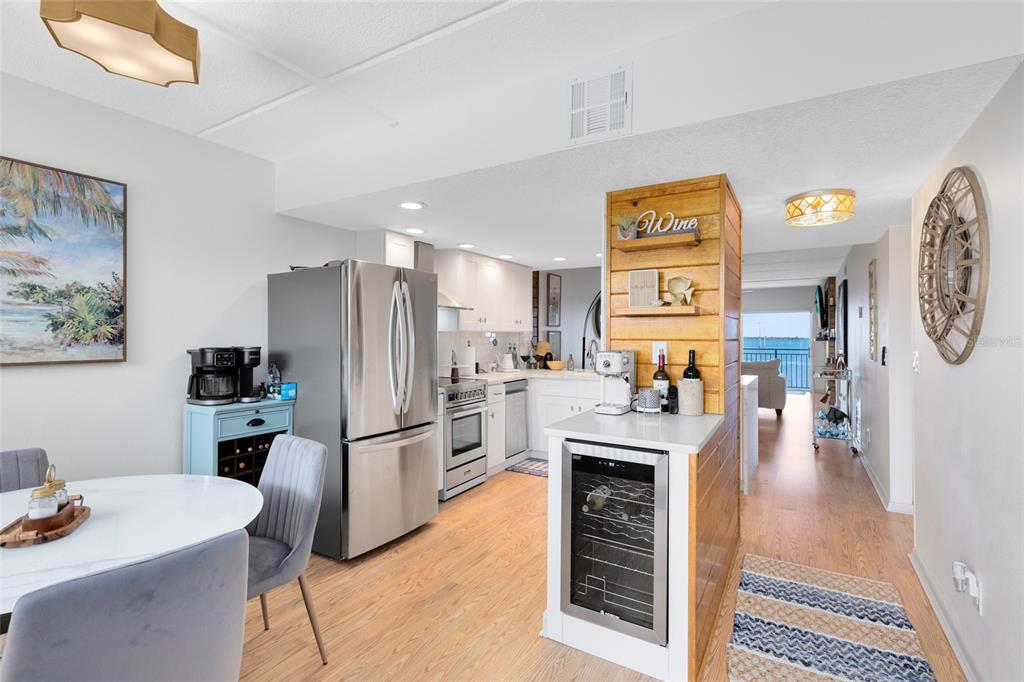 A kitchen with stainless steel appliances, a wood-paneled wine bar, and an adjacent dining area — 3901 DIXIE HIGHWAY NE UNIT 409, PALM BAY, FL