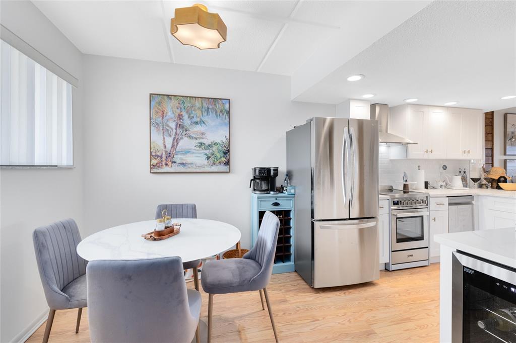 A dining area with a round table and grey chairs sits beside a modern kitchen — 3901 DIXIE HIGHWAY NE UNIT 409, PALM BAY, FL