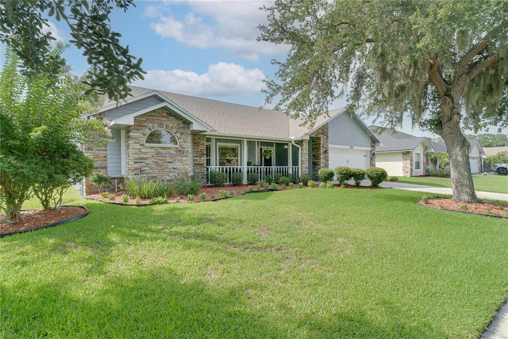 A single-story house with a stone facade, blue siding, a front porch, and a lawn — 123 RACHEL LIN LANE, ST CLOUD, FL