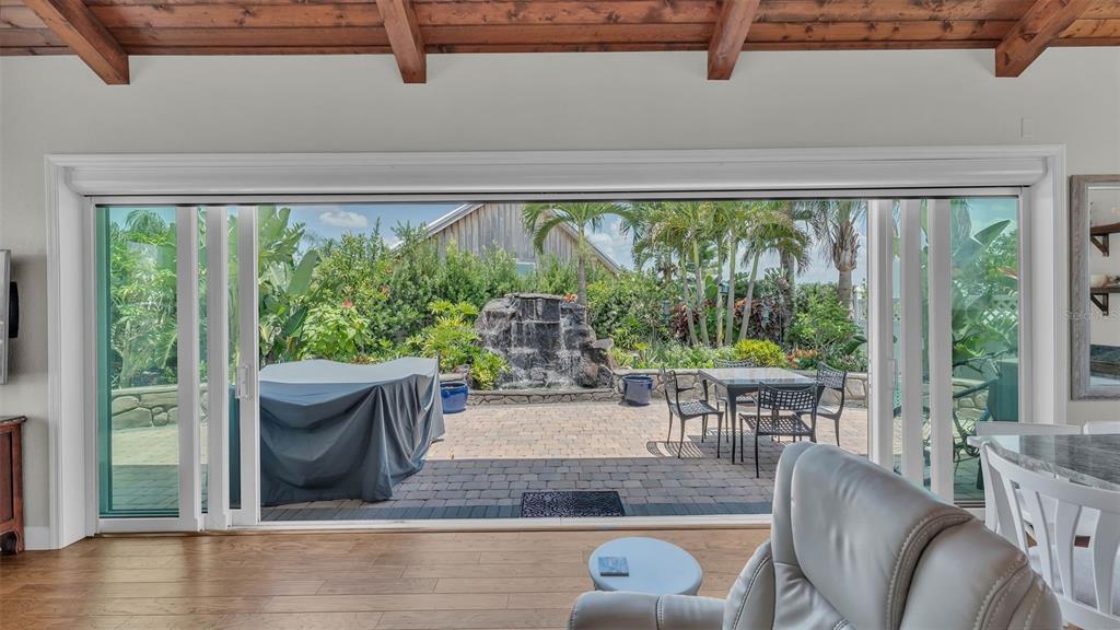 A living room with wood floors looks out through large sliding doors to a patio — 3003 WOOD DUCK DRIVE, POLK CITY, FL