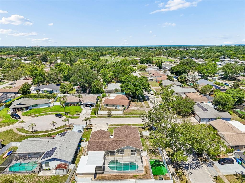 A covered patio with a swimming pool, ceiling fans, and a white painted brick wall — 2959 MAPLE COURT, DUNEDIN, FL