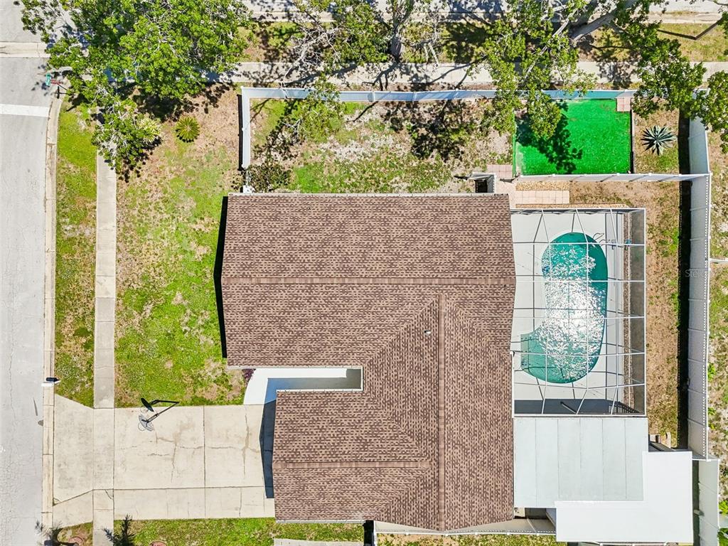 An aerial view shows a suburban neighborhood with houses, swimming pools, and mature trees — 2959 MAPLE COURT, DUNEDIN, FL