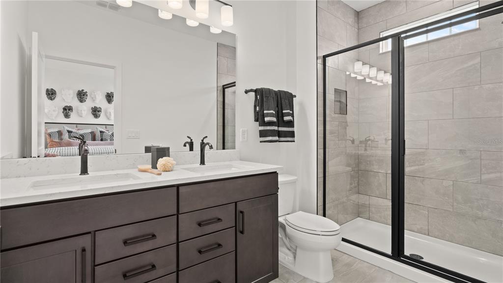 A bathroom features a double vanity with dark cabinets, a white countertop, and a glass shower — 15231 GROVESIDE ROAD, WINTER GARDEN, FL
