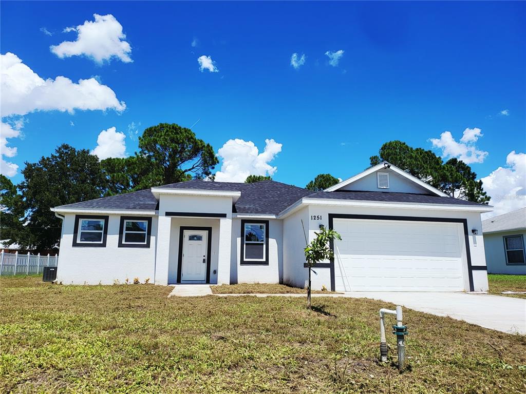 A single-story white house with a black-trimmed entryway and a two-car garage — 1098 HAMMACHER AVENUE SW, PALM BAY, FL