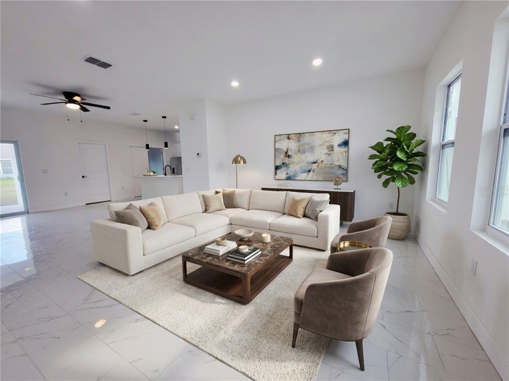A bright living room features a large sectional sofa, marble coffee table, and tile flooring — 1098 HAMMACHER AVENUE SW, PALM BAY, FL