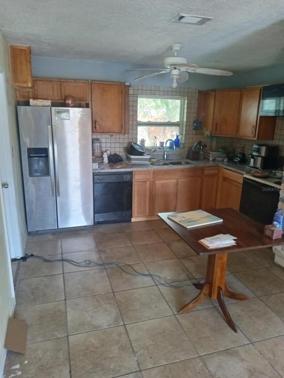 A kitchen with wood cabinets, stainless steel appliances, tile flooring, and a small wooden table — 6631 ROSATI LANE S, ST PETERSBURG, FL