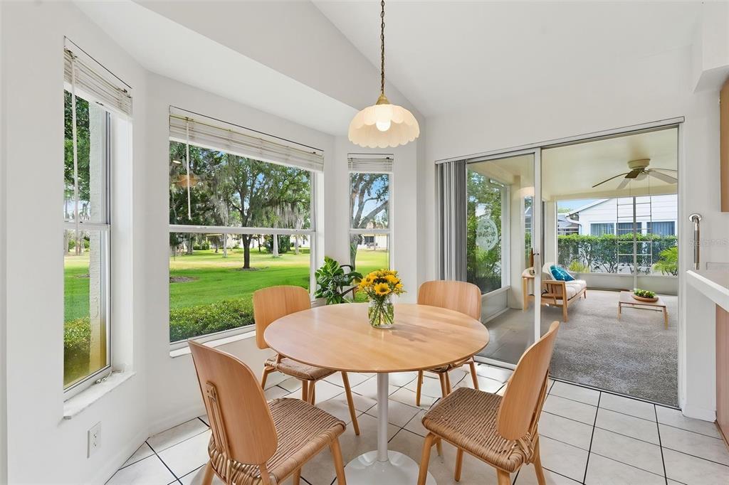A bright living room features hardwood floors, a light-colored sofa, and a wooden front door — 1444 CANBERLEY COURT, TRINITY, FL