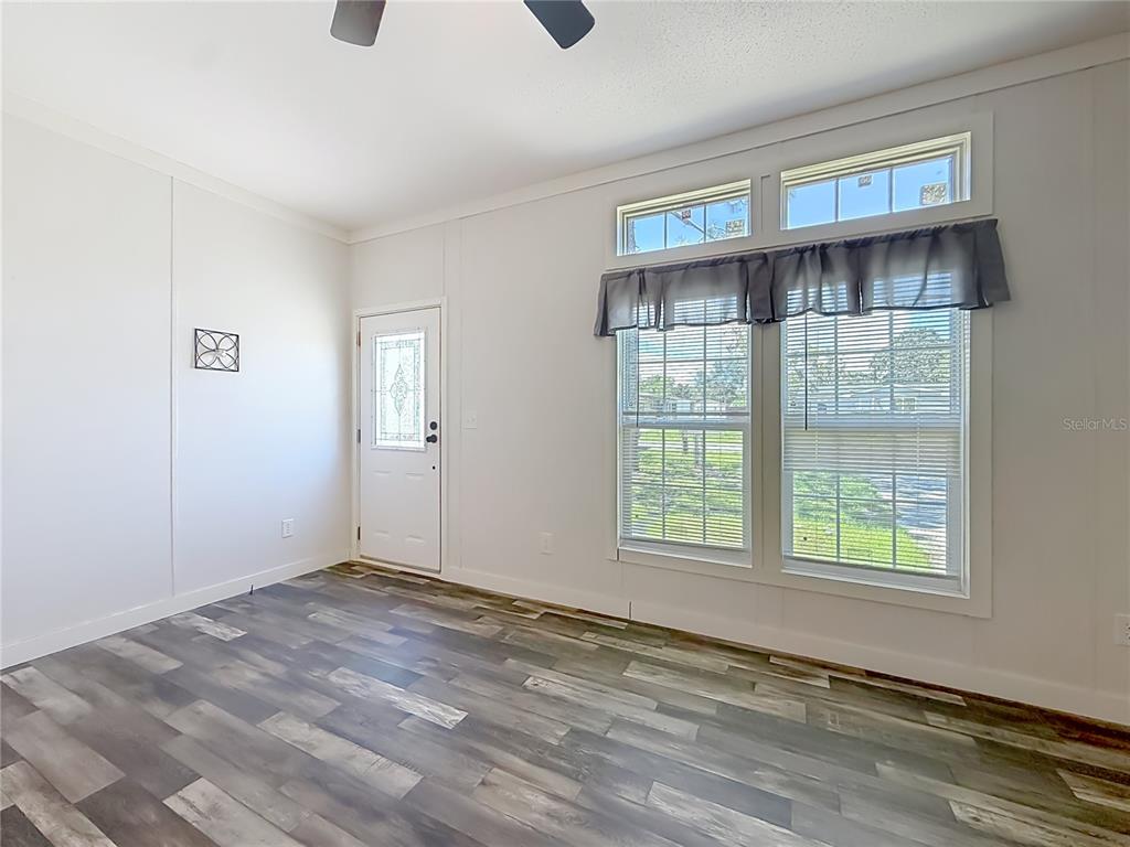 A room with white walls, wood-look flooring, a white door, and two windows with blinds — 5360 W CARAWAY PLACE, LECANTO, FL