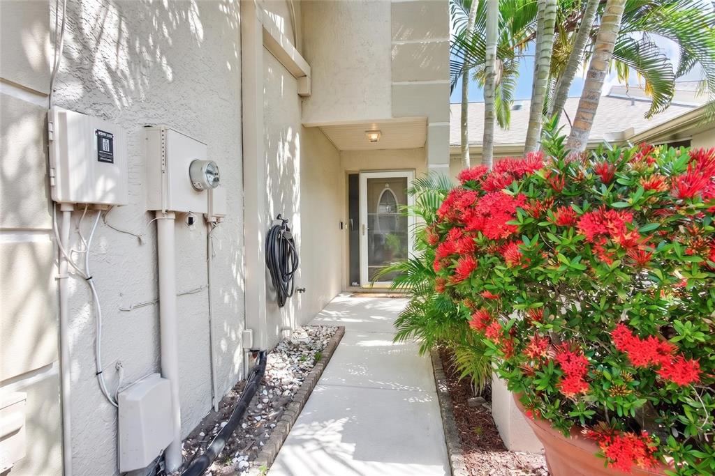 A two-story townhouse with a two-car garage and arched windows under a sunset sky — 2524 W BROOK LANE, CLEARWATER, FL