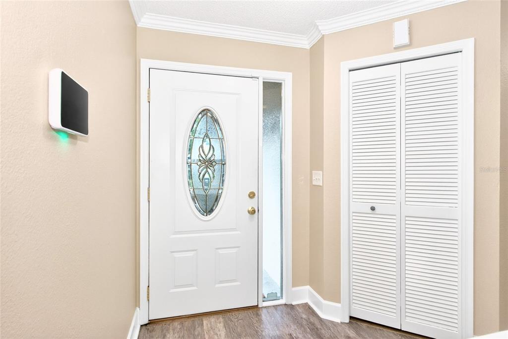 A two-story duplex with beige siding, two garage doors, and a palm tree in front — 2524 W BROOK LANE, CLEARWATER, FL