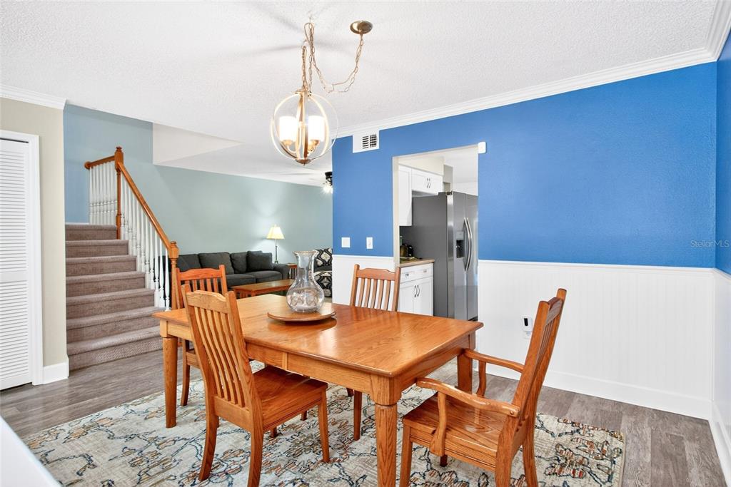 A two-story duplex with beige stucco siding, two garage doors, and a palm tree — 2524 W BROOK LANE, CLEARWATER, FL