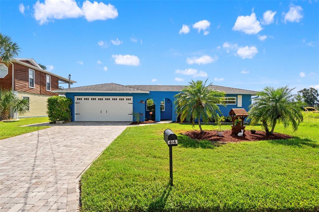 A blue single-story house with a white garage door and a paved driveway — 4114 ORCHID DRIVE, HERNANDO BEACH, FL