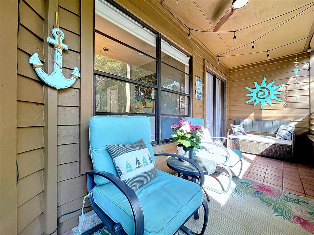 A two-story brown apartment building features screened-in porches and surrounding landscaping — 1006 LENNOX ROAD W UNIT 1006, PALM HARBOR, FL