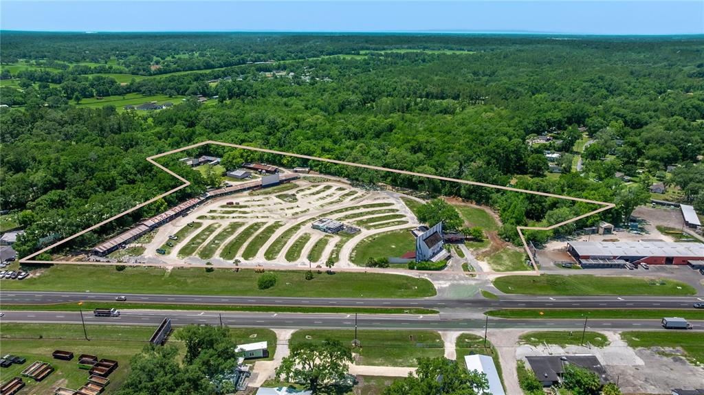 An aerial view shows a large, fenced-in lot containing a drive-in theater and flea market — 4850 S PINE AVENUE, OCALA, FL