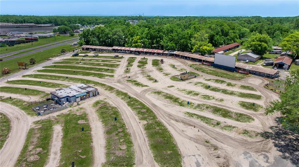 An aerial view shows a large outdoor flea market and drive-in theater with dirt parking rows — 4850 S PINE AVENUE, OCALA, FL