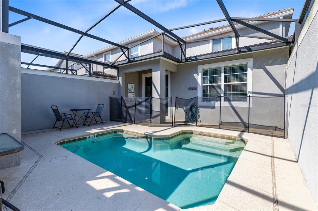 A small backyard swimming pool is enclosed by a screened-in lanai and a safety fence — 3087 JULIET DRIVE, KISSIMMEE, FL