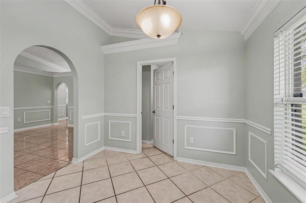 A room with light green walls, white wainscoting, tile flooring, and an arched entryway — 817 LAKE DOE BOULEVARD, APOPKA, FL