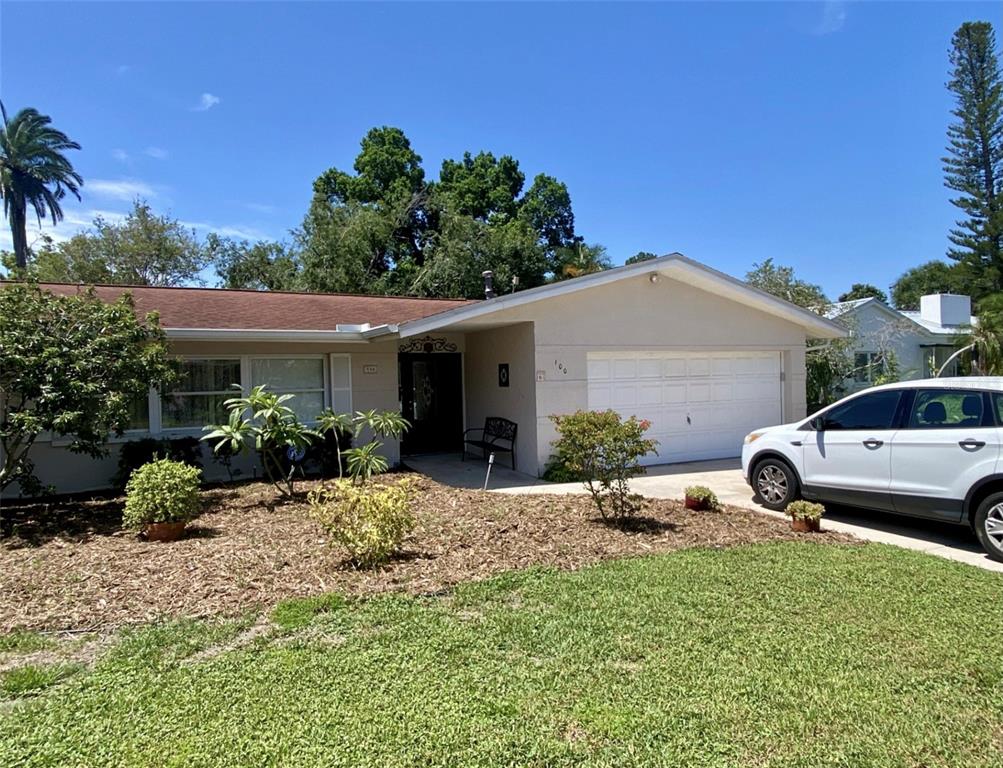 A single-story house with a white garage, a front lawn, and a white car parked outside — 100 59TH AVENUE S, ST PETERSBURG, FL