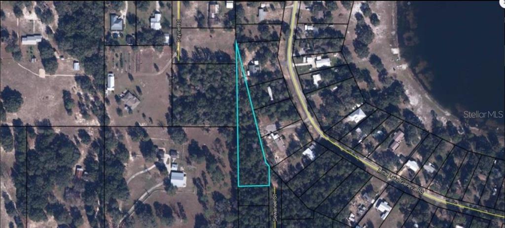 An aerial map shows a vacant, irregularly shaped lot highlighted in blue near a road — 7058 SEWANEE STREET, KEYSTONE HEIGHTS, FL