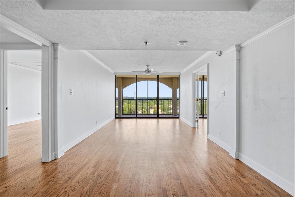 An empty living room with hardwood floors, white walls, and a balcony with a view — 3211 W SWANN AVENUE UNIT 1103, TAMPA, FL