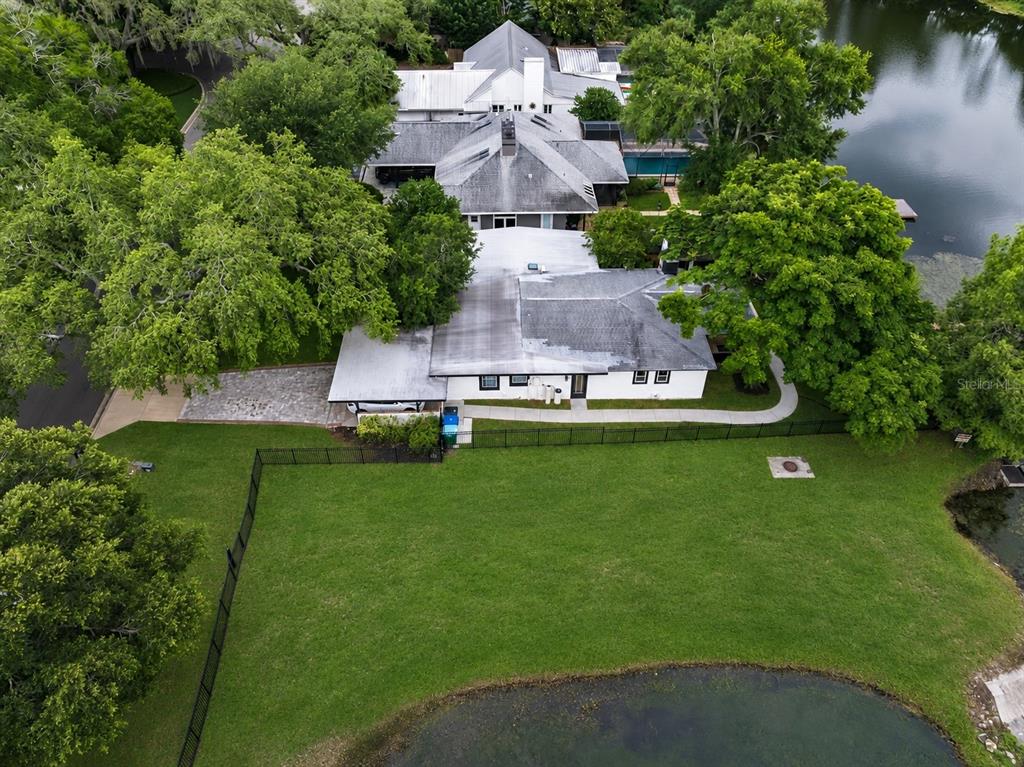 An aerial view shows a white house with a gray roof beside a lake — 2227 HOWARD DRIVE, WINTER PARK, FL
