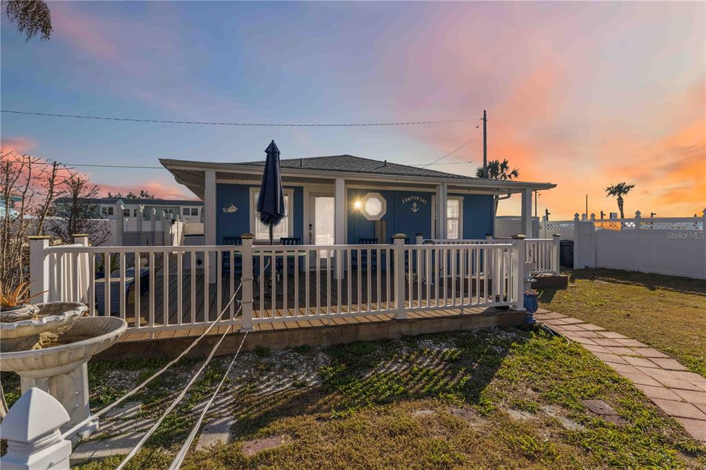 A blue house with a white deck and fence under a sunset sky — 111 9TH STREET N, BRADENTON BEACH, FL