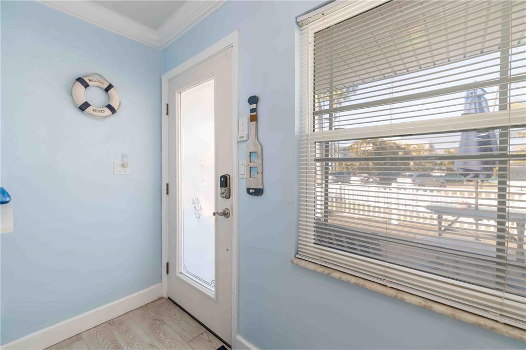 An entryway with light blue walls, a white door, and a window with blinds — 111 9TH STREET N, BRADENTON BEACH, FL