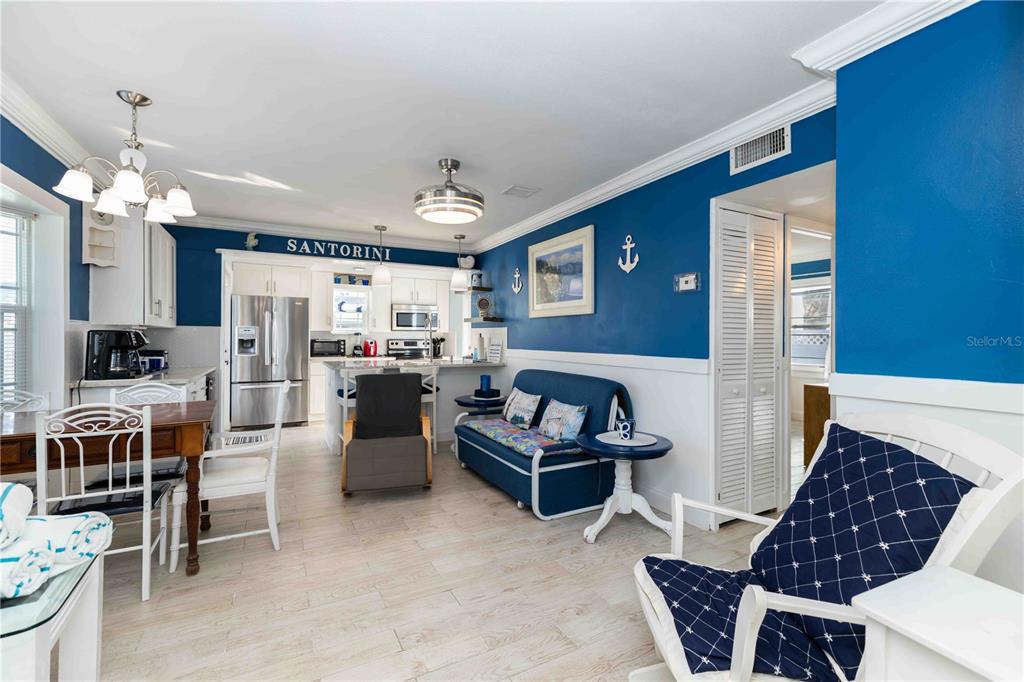 A kitchen and living area feature blue walls, white cabinetry, and nautical decor — 111 9TH STREET N, BRADENTON BEACH, FL