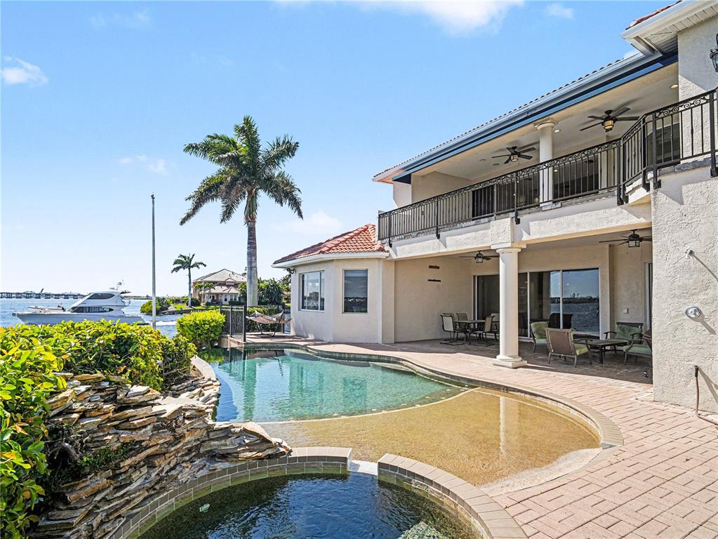 A single-story house with a tiled roof, a two-car garage, and palm trees in front — 102 12TH AVENUE E, PALMETTO, FL