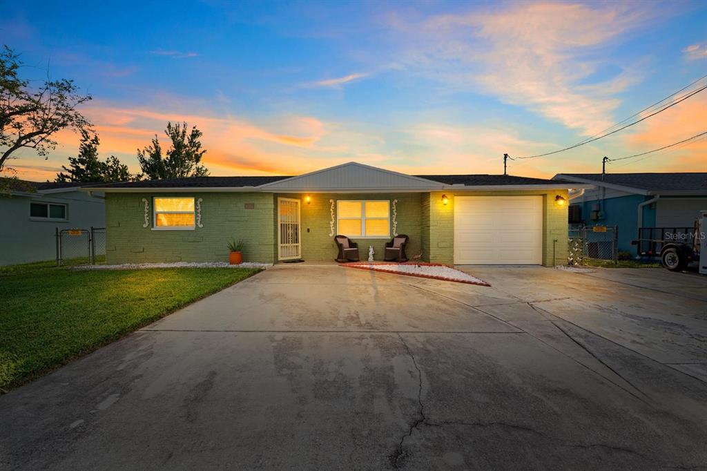 A single-story house with a green brick exterior, a concrete driveway, and a one-car garage — 8505 OLD POST ROAD, PORT RICHEY, FL