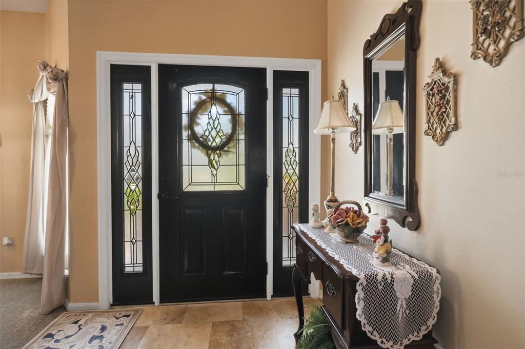 The front entrance features a dark brown door with sidelights, a wreath, and two large planters — 23427 PINE LAKE STREET, LAND O LAKES, FL