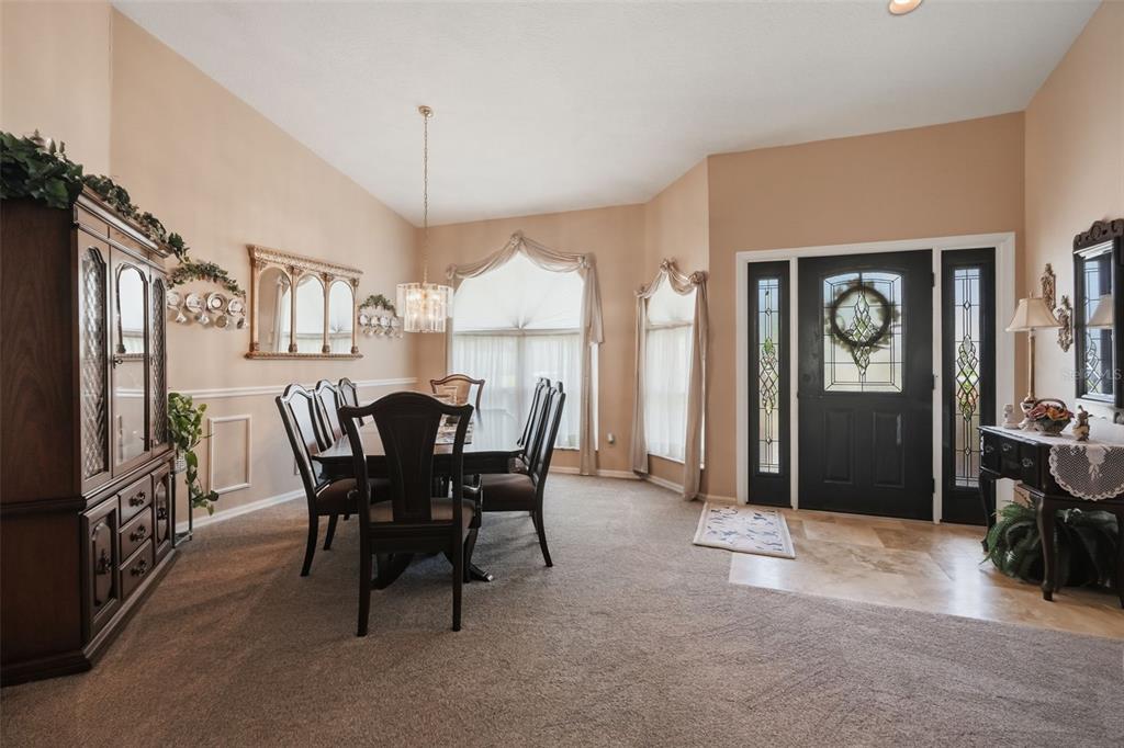 An entryway features a black front door with sidelights, tile flooring, and a wooden console table — 23427 PINE LAKE STREET, LAND O LAKES, FL