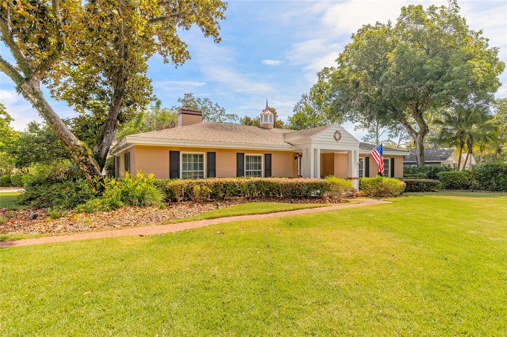 A single-story tan brick house with black shutters, a cupola, and a front lawn — 1600 S PENNSYLVANIA AVENUE, WINTER PARK, FL