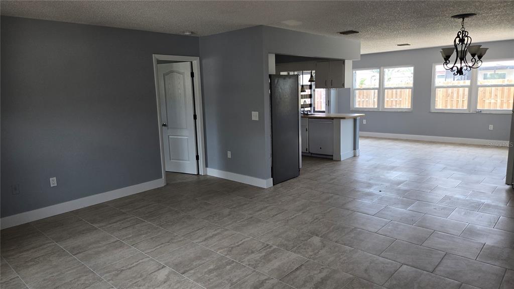 An open-concept living area features gray walls, tile flooring, and a kitchen with white cabinets — 347 HOLLY ROAD, VENICE, FL