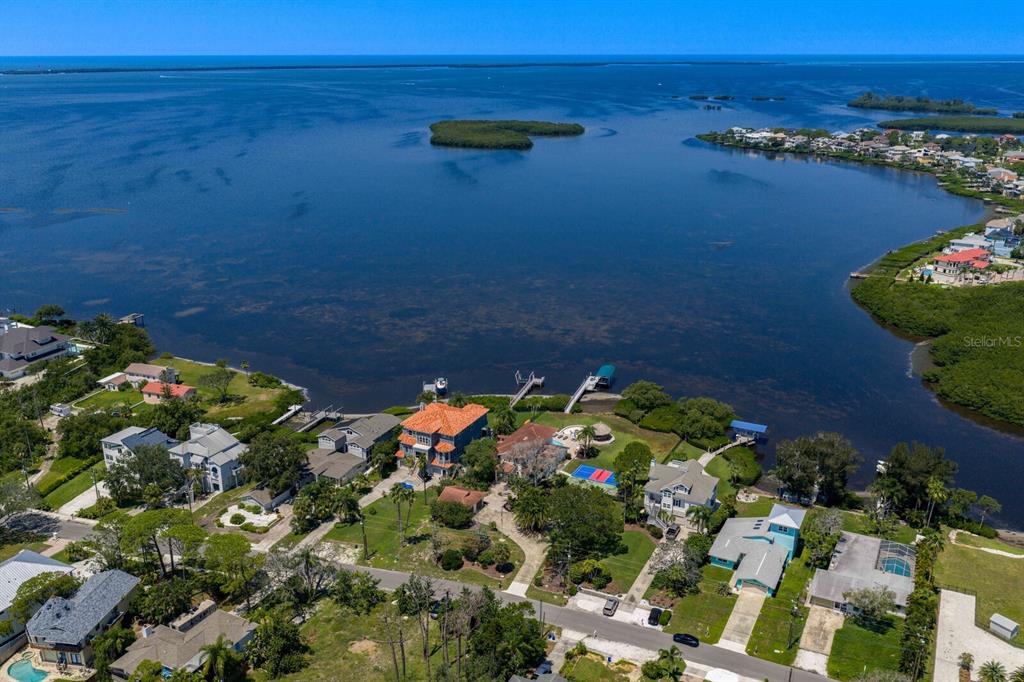 A beige house with a two-car garage and a paved driveway under a blue sky — 1632 SEA BREEZE DRIVE, TARPON SPRINGS, FL