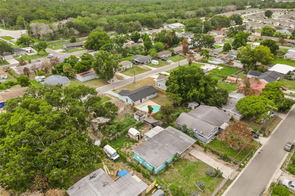 An aerial view shows a residential neighborhood with several houses, trees, and a swimming pool — 116 HARBOR DRIVE, WINTER HAVEN, FL