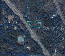 An aerial map shows a vacant, trapezoidal plot of land outlined in blue next to a highway — SE WACAHOOTA RD, MICANOPY, FL