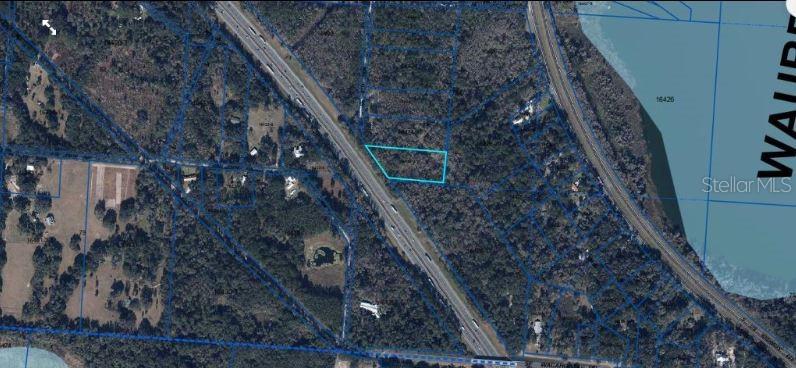 This aerial map shows a highlighted parcel of land situated between two highways — SE WACAHOOTA RD, MICANOPY, FL