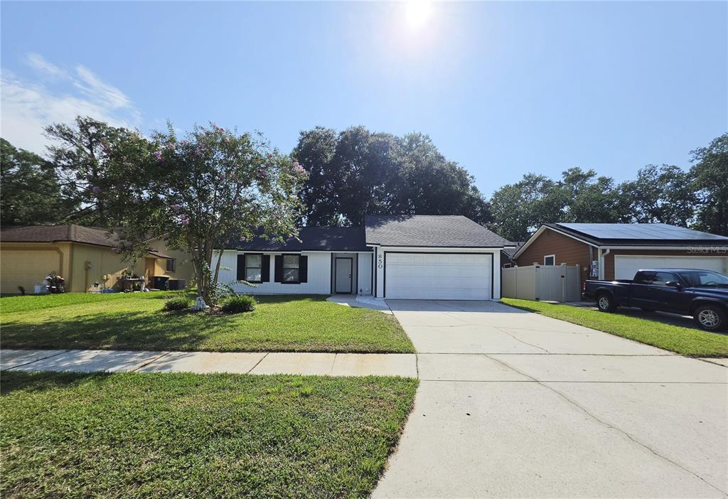 A single-story house with a white exterior, black trim, and a two-car garage — 850 ARIES ROAD W, JACKSONVILLE, FL